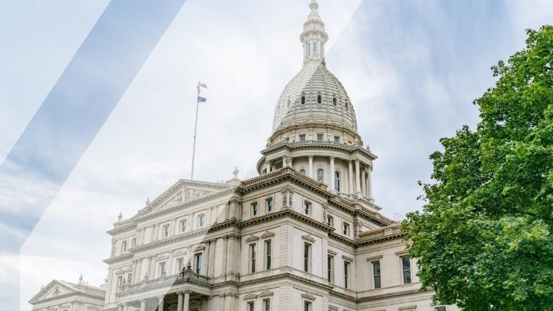 Transparent MCAN logo over top of a photo of the Capital Building