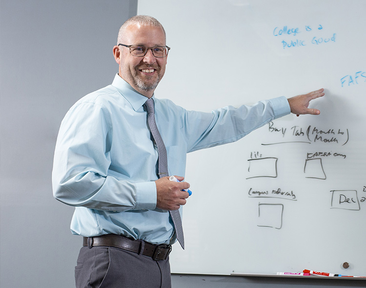 A man pointing at a white board