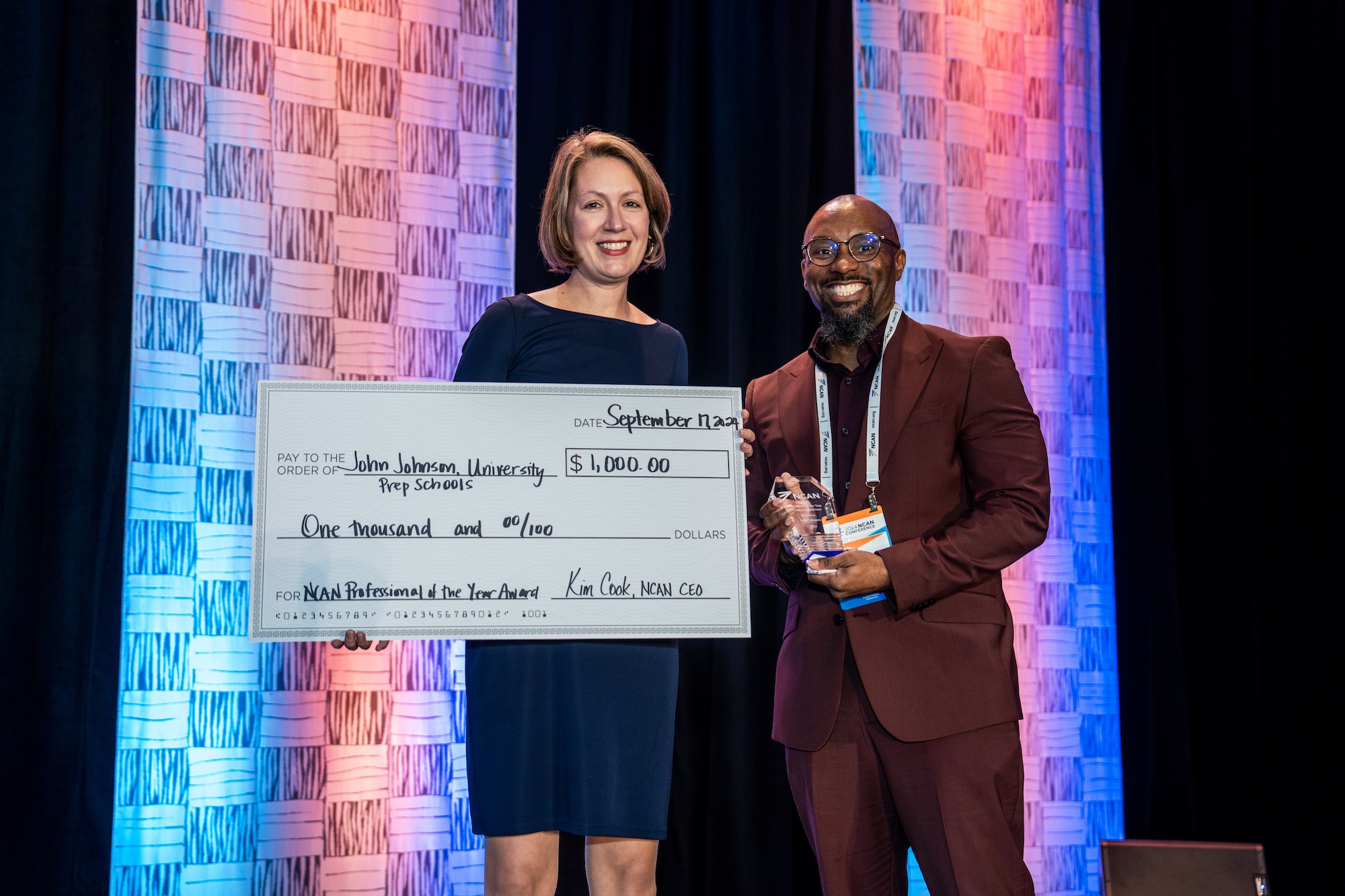 John Johnson holding a large check and his award.